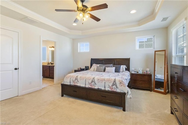 carpeted bedroom with multiple windows, ensuite bath, ornamental molding, and a raised ceiling