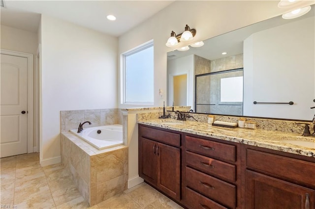 bathroom with vanity and shower with separate bathtub