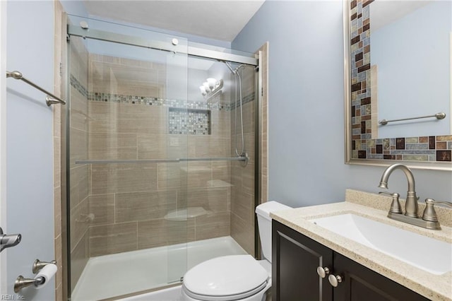 bathroom featuring an enclosed shower, vanity, and toilet