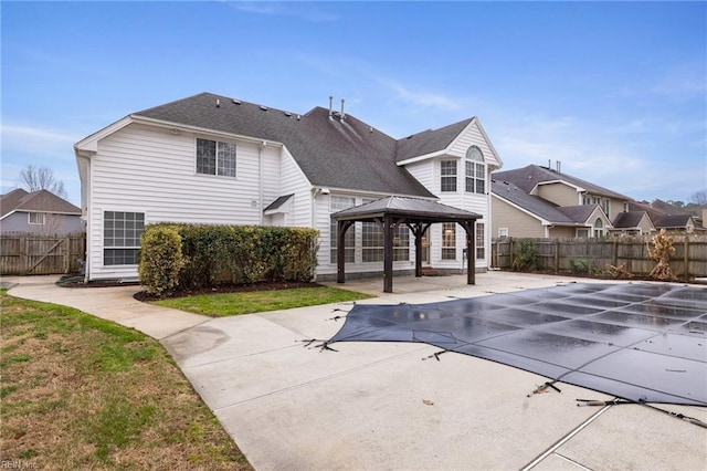 back of property featuring a gazebo, a yard, a covered pool, and a patio