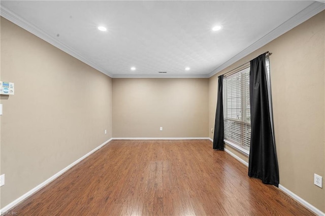 spare room featuring crown molding and light wood-type flooring