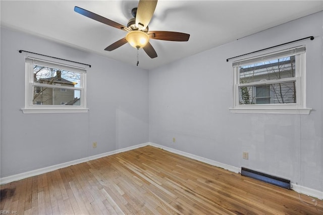 empty room with ceiling fan, a healthy amount of sunlight, and light wood-type flooring