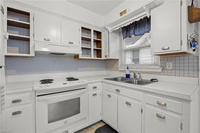 kitchen featuring sink, electric range, decorative backsplash, and white cabinets