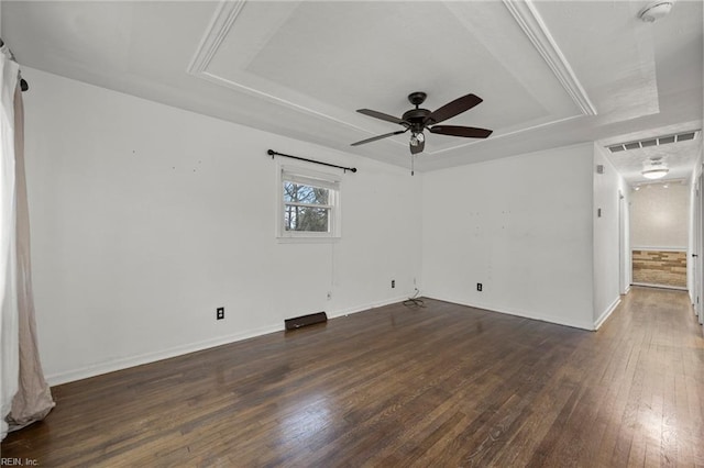 spare room with dark hardwood / wood-style floors, a raised ceiling, and ceiling fan