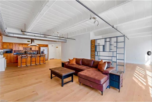 living area featuring light wood-type flooring and baseboards