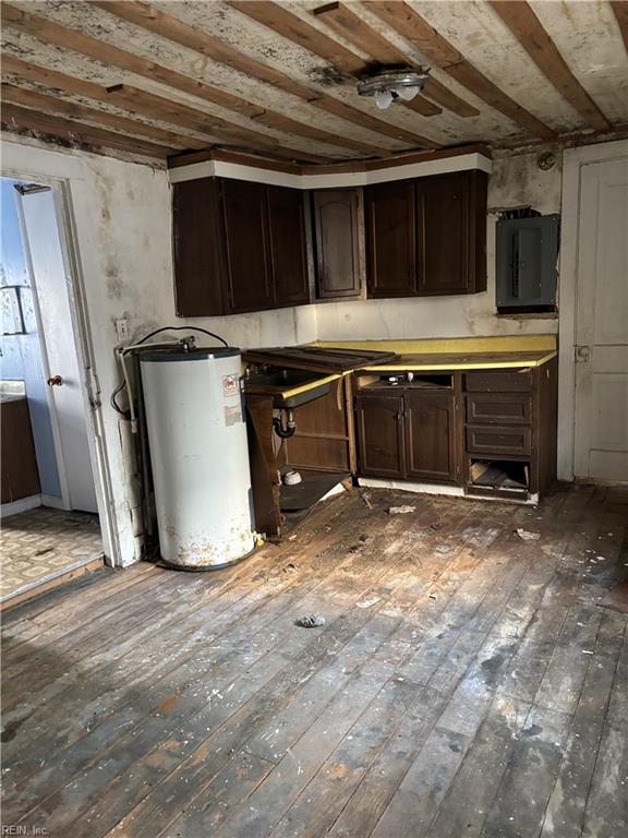 kitchen featuring dark brown cabinets, dark hardwood / wood-style flooring, electric panel, and water heater