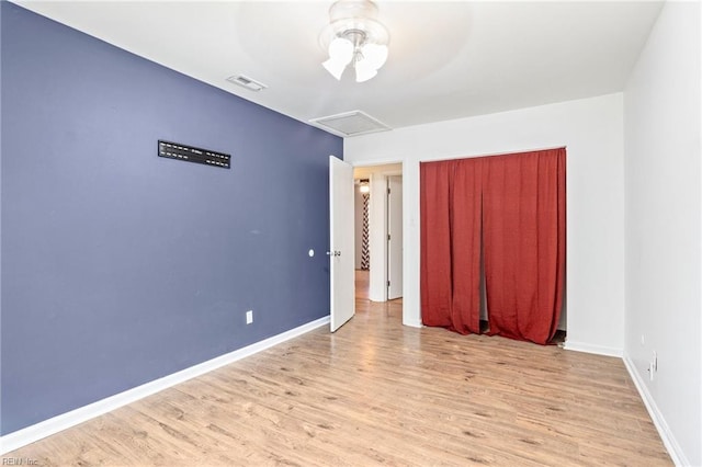 unfurnished bedroom featuring ceiling fan, light hardwood / wood-style floors, and a closet