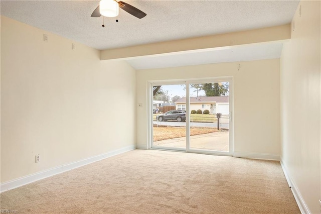 spare room with ceiling fan, carpet floors, vaulted ceiling with beams, and a textured ceiling