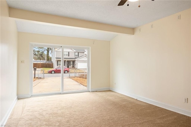 carpeted spare room featuring ceiling fan, a textured ceiling, and beam ceiling