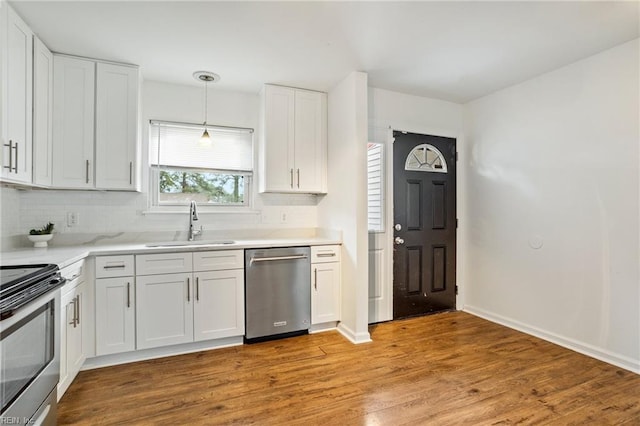 kitchen with pendant lighting, sink, white cabinets, and appliances with stainless steel finishes