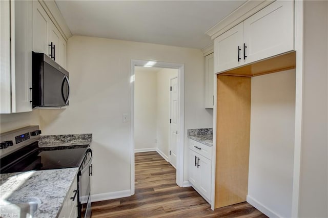 kitchen with light stone counters, white cabinets, and appliances with stainless steel finishes