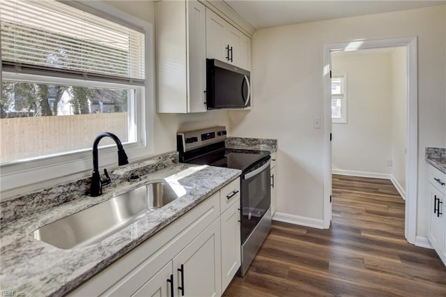 kitchen with appliances with stainless steel finishes, sink, white cabinets, and dark hardwood / wood-style flooring