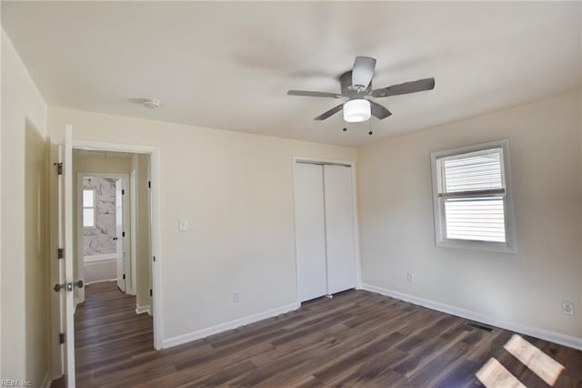 unfurnished bedroom with dark wood-type flooring, ceiling fan, and a closet