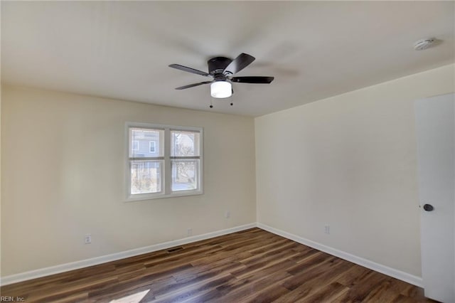 spare room featuring dark wood-type flooring and ceiling fan