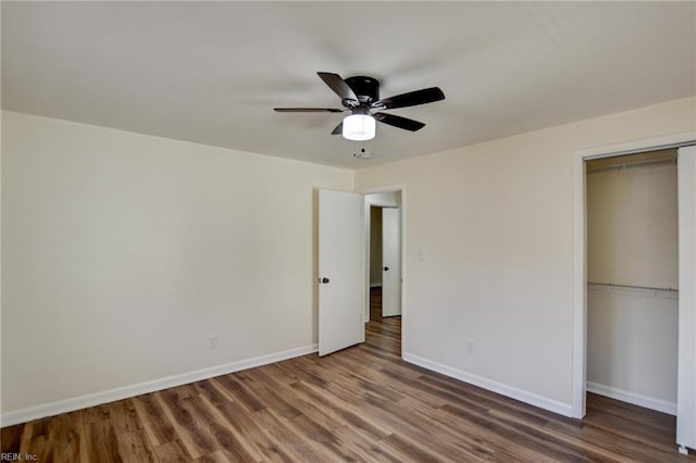 unfurnished bedroom with dark wood-type flooring, ceiling fan, and a closet