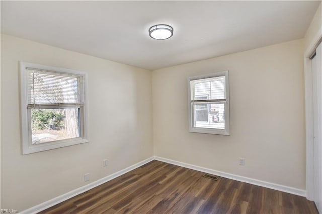 spare room with dark hardwood / wood-style flooring