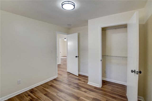 unfurnished bedroom featuring wood-type flooring and a closet