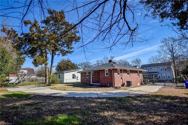 view of side of home featuring cooling unit and a lawn