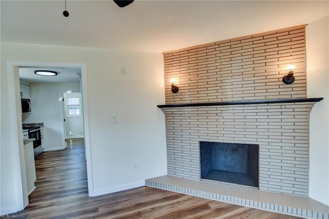 unfurnished living room featuring wood-type flooring and a fireplace