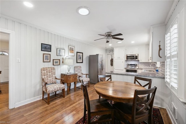 dining space featuring sink, light hardwood / wood-style flooring, and ceiling fan