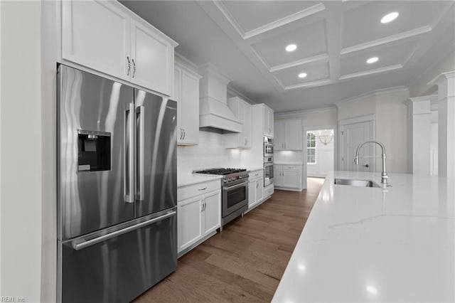 kitchen with custom range hood, ornamental molding, high end appliances, and a sink