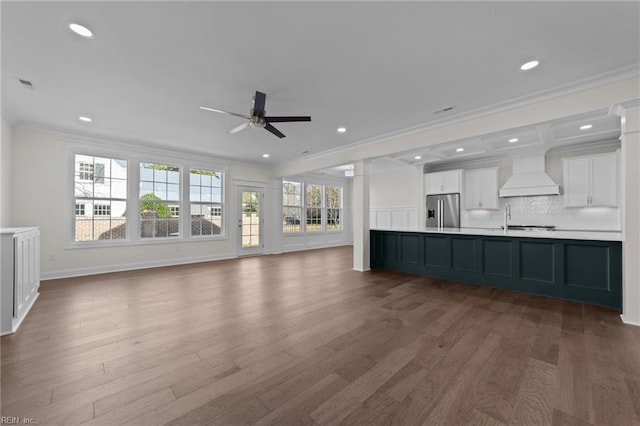 unfurnished living room featuring a ceiling fan, ornamental molding, wood finished floors, and recessed lighting