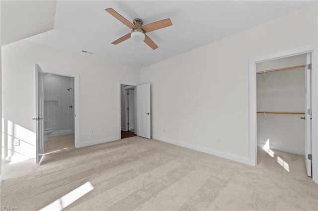 unfurnished bedroom featuring baseboards, visible vents, a walk in closet, carpet flooring, and a closet