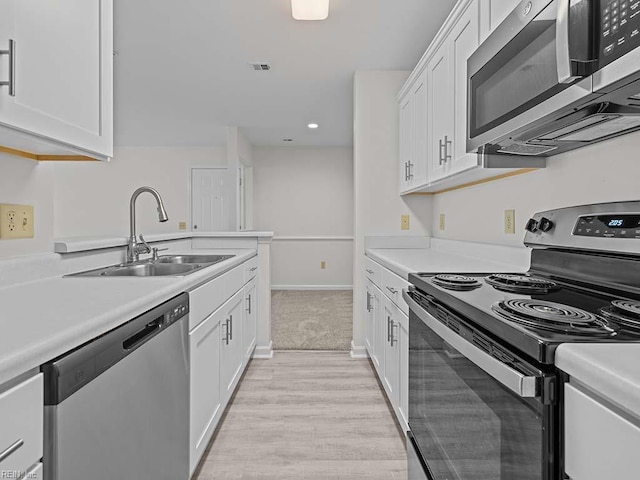 kitchen with visible vents, appliances with stainless steel finishes, light countertops, and a sink