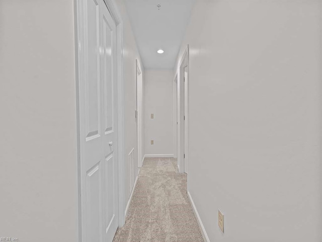 hallway with recessed lighting, baseboards, and light colored carpet