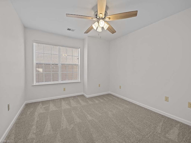 carpeted empty room featuring baseboards, visible vents, and ceiling fan