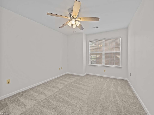 carpeted empty room featuring visible vents, ceiling fan, and baseboards