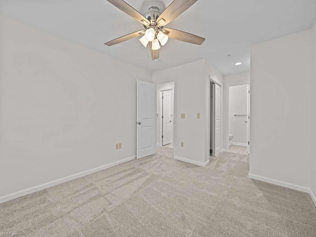 unfurnished bedroom featuring ensuite bath, recessed lighting, light colored carpet, and baseboards