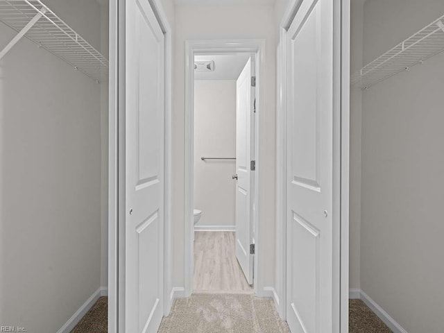 hallway featuring carpet flooring and baseboards