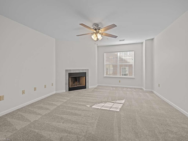 unfurnished living room featuring a ceiling fan, baseboards, visible vents, carpet floors, and a tile fireplace