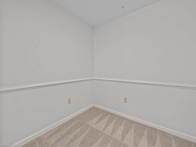 carpeted empty room featuring baseboards