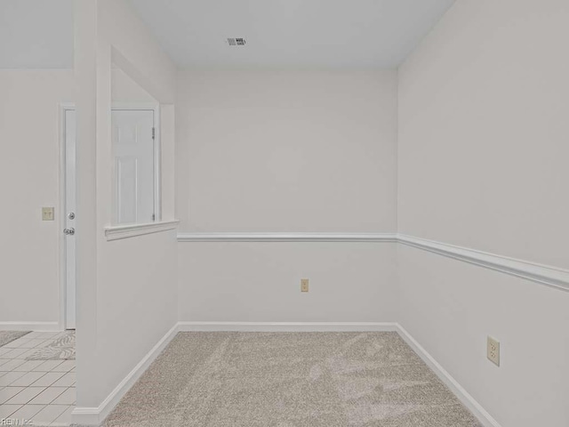 carpeted empty room with visible vents and baseboards