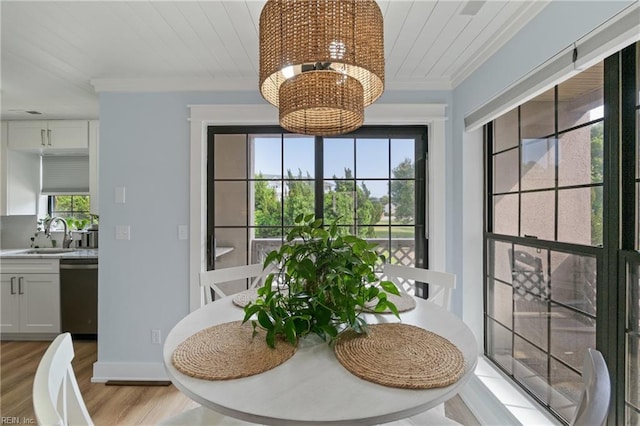 dining area with sink, an inviting chandelier, wood ceiling, crown molding, and light wood-type flooring