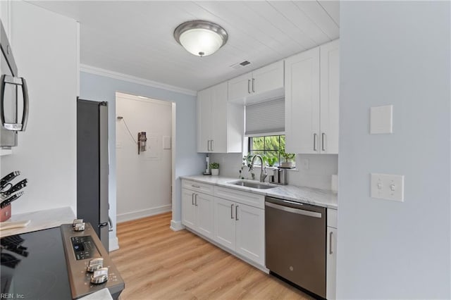 kitchen featuring appliances with stainless steel finishes, white cabinetry, sink, crown molding, and light hardwood / wood-style flooring