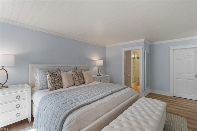 bedroom featuring crown molding, hardwood / wood-style flooring, and ensuite bath