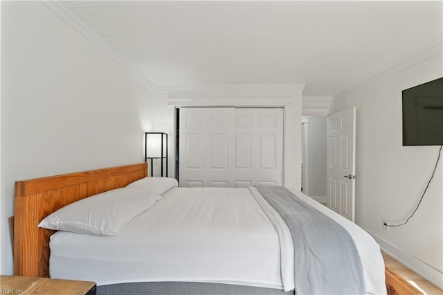 bedroom featuring crown molding, wood-type flooring, and a closet