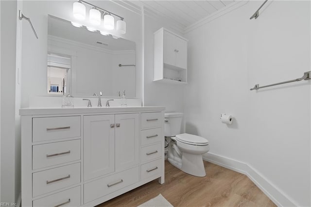 bathroom with vanity, wood-type flooring, ornamental molding, and toilet