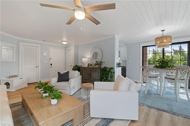 living room with light hardwood / wood-style flooring, ornamental molding, and ceiling fan