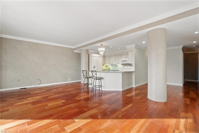 unfurnished living room featuring crown molding, wood-type flooring, and decorative columns