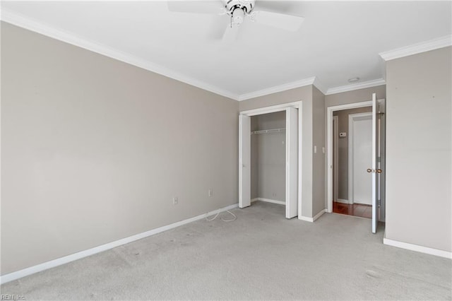 unfurnished bedroom with light carpet, ornamental molding, a closet, and ceiling fan