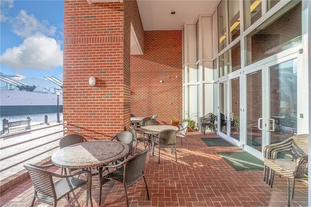 balcony featuring a water view and french doors