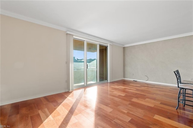 empty room featuring crown molding and light hardwood / wood-style floors