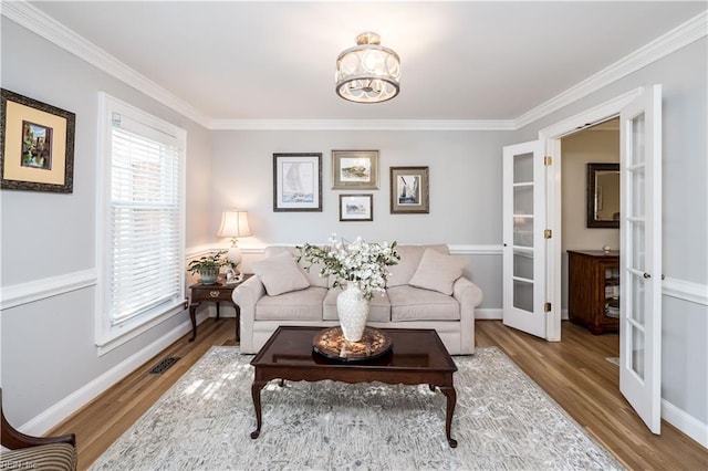 living room featuring crown molding, hardwood / wood-style flooring, and french doors