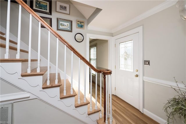 foyer with crown molding and light hardwood / wood-style flooring