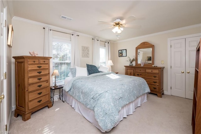 carpeted bedroom with crown molding, a closet, and ceiling fan