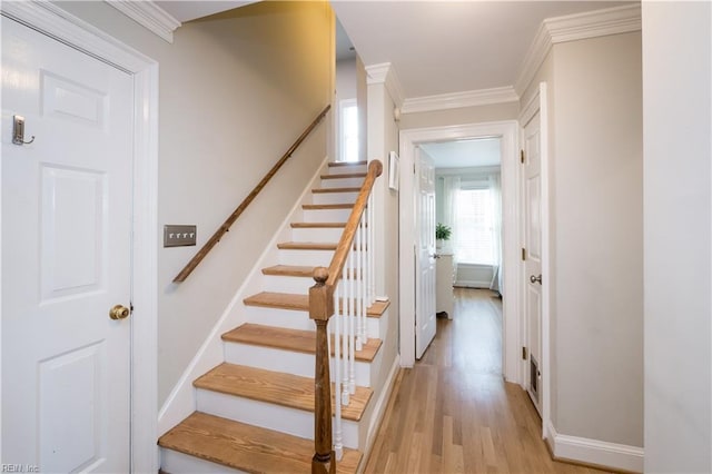 stairs featuring crown molding and hardwood / wood-style flooring